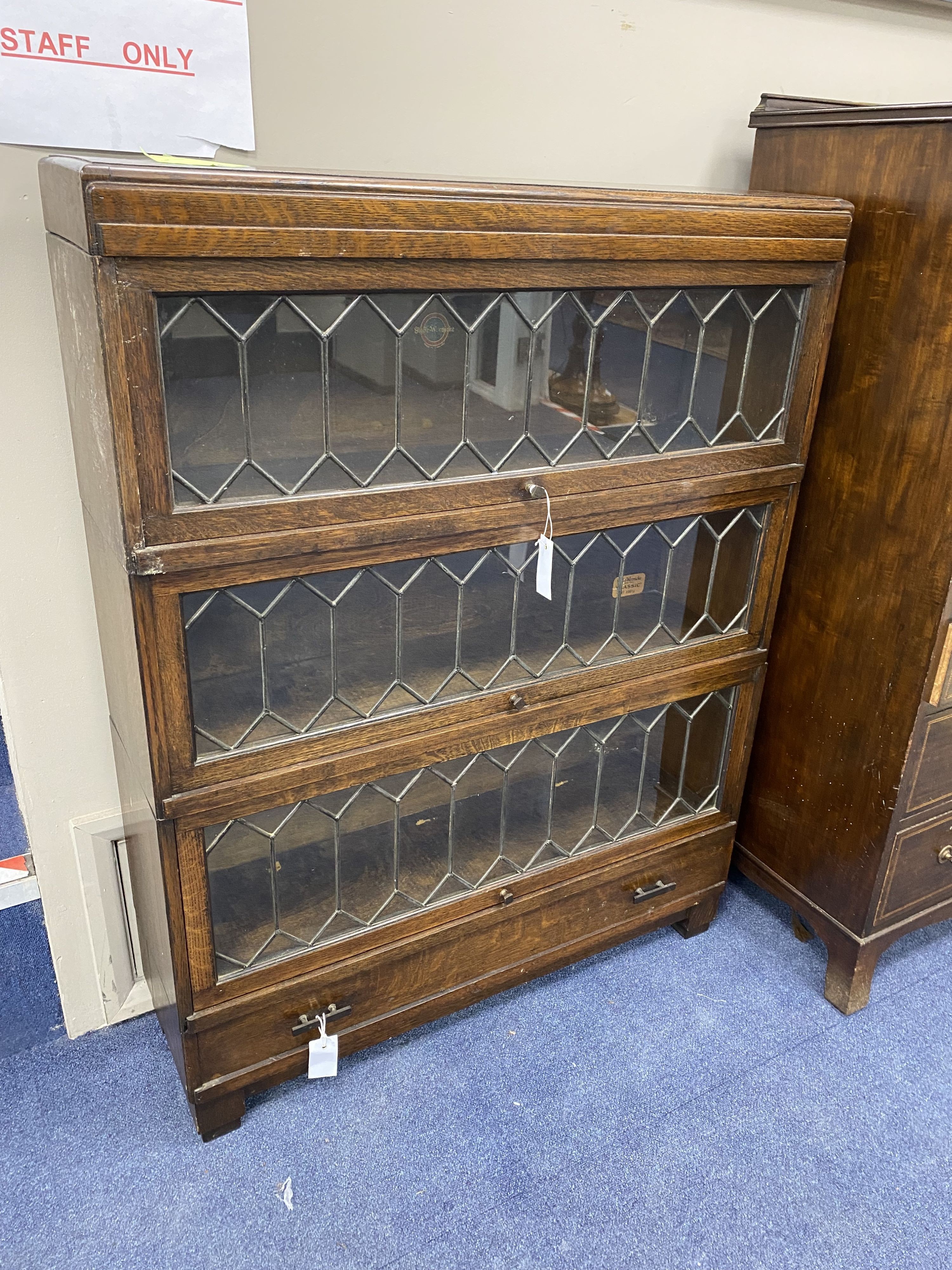 A Globe Wernicke oak three section leaded bookcase, length 85cm, depth 24cm, height 110cm